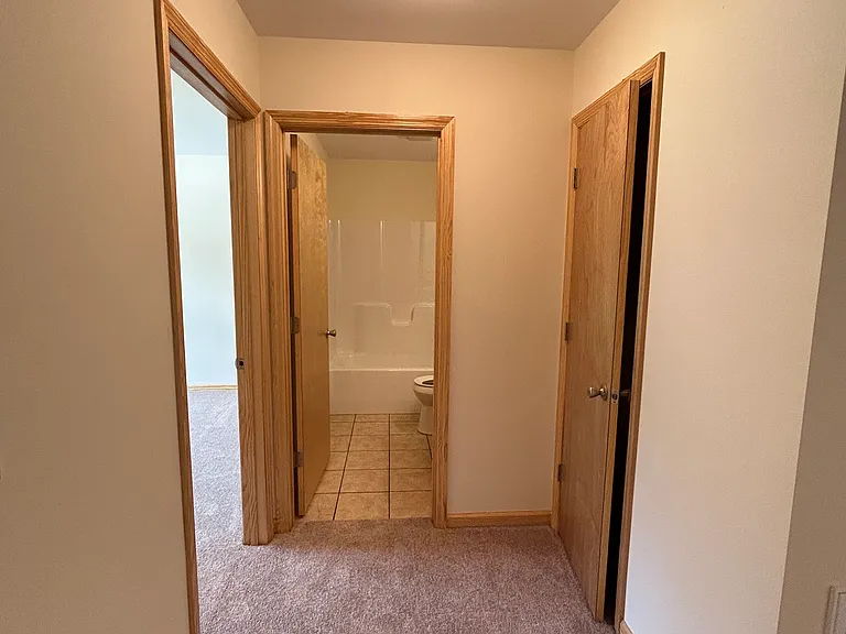 Hallway with entrance to secondary bedroom and linen closet
