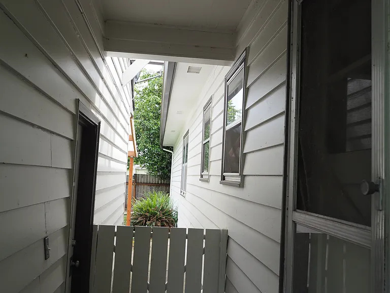 Covered breezeway between garage and house, looking east