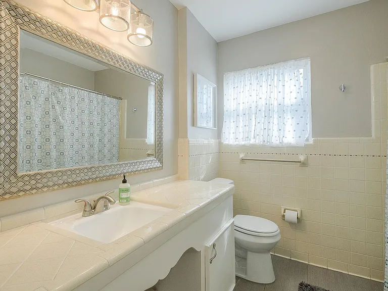 The fun kitchy hall bathroom has been well preserved and mostly left in its original condition. Some updates have been made. It has a tub and shower combination, several cabinets with good storage space and a laundry hamper that can be used as storage as