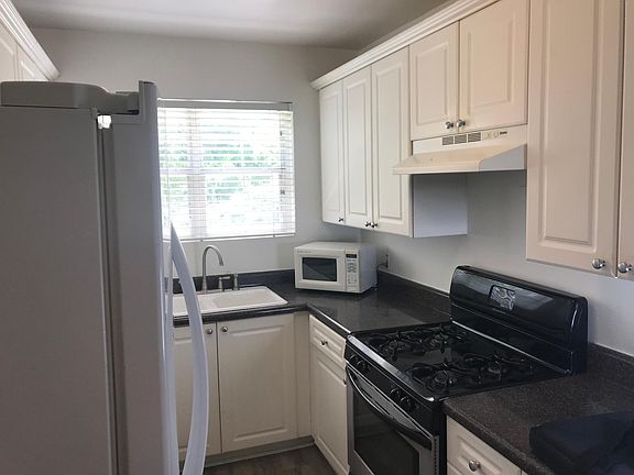 Bright galley kitchen. 
Please note: The stove has been updates since this photo was taken. Microwave is no longer present.
