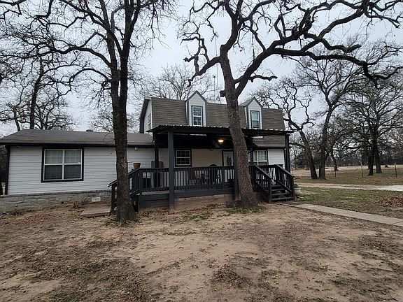Front of home with covered porch w/ ceiling fan