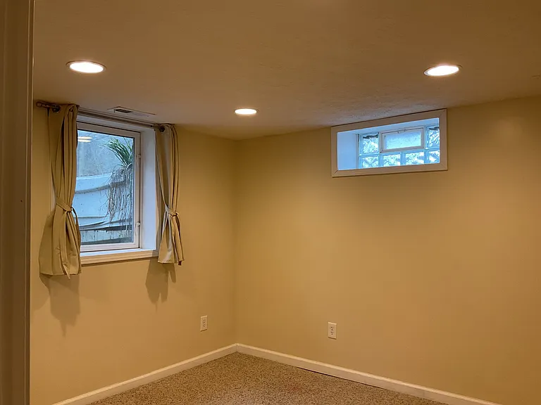 Second of 2 lower level bedrooms with one full size and one daylight window and carpeting.