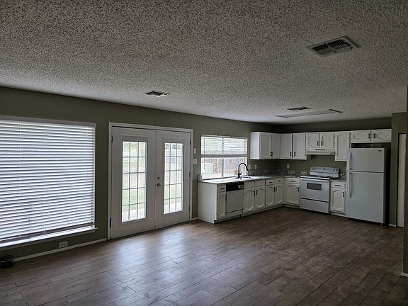 Open concept living and kitchen area with sturdy wood grain tile flooring