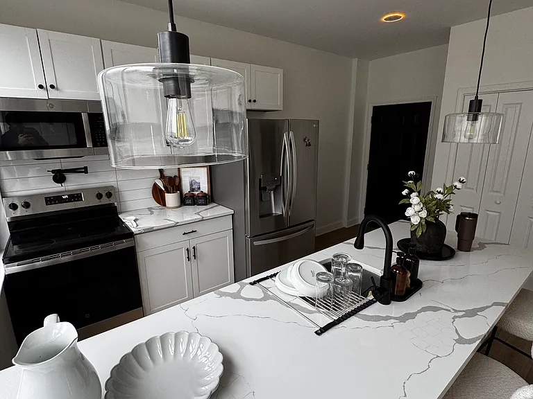 Full-size kitchen appliances, a refrigerator with an ice maker, and pot filler above the stove.