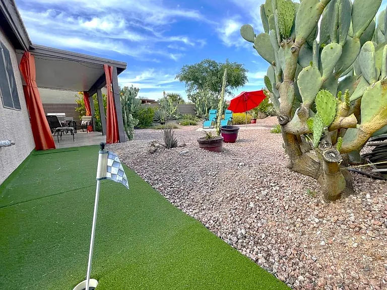 Inviting covered patio with couch, TV, tile dining table for 6 plus Putting Green, Propane glass Firepit/Dining Table, Adirondack chairs, plus propane gas grill to enjoy!