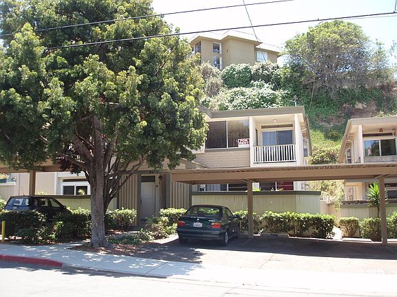 EXTERIOR OF BUILDING WITH UPPER BALCONY- PARKING SPOT IS NEXT TO BMW IN PHOTO - UNIT IS 2ND STORY WITH FOR RENT SIGN IN WINDOW