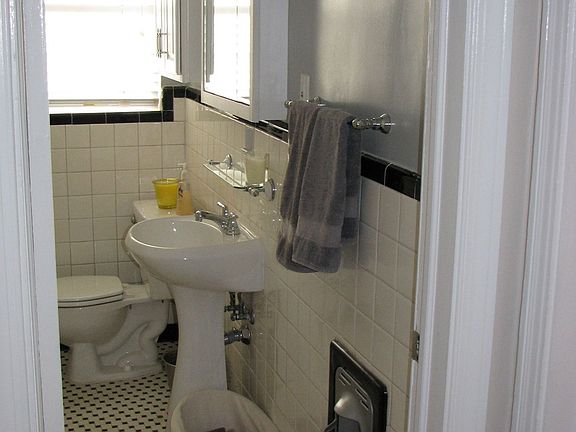 Bath has original tile pattern and in-wall gas heater.