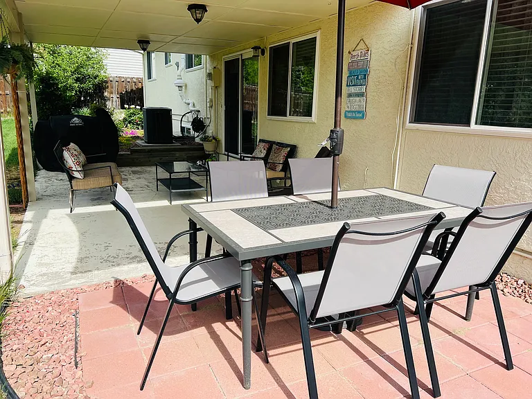 Peaceful backyard patio and seating area available for guests to enjoy fresh air.