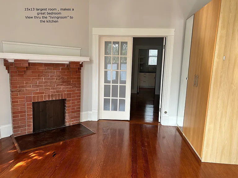 2nd view of the same 15 x 13 "bedroom.
Non function fireplace and closet space. French doors to the "livingroom" and thru to the Kitchen. This apt spans front to back of the structure and all across the back in an L shape so there are long views.
