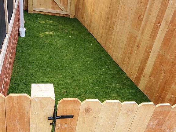 Newly fenced in yard + pet ready turf with infill.