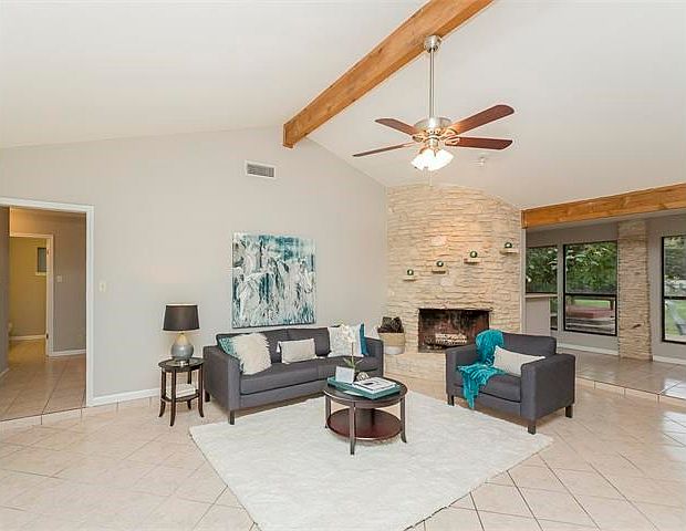Open living with fireplace.  Lots of natural light, high ceilings. Open doorway on left to 3 bedrooms second bath and laundry room.