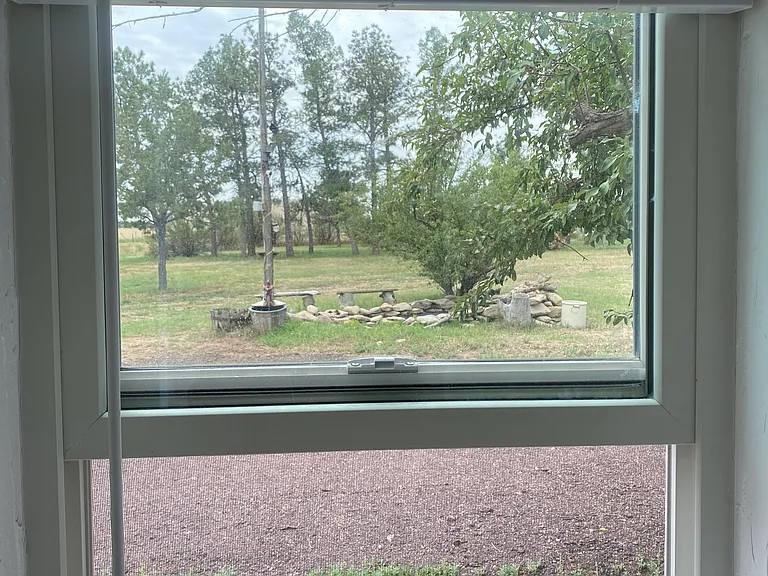 The blinds can also be pulled open to enjoy the view of the modest waterfall and pond and bank of trees surrounding the south side of the house.