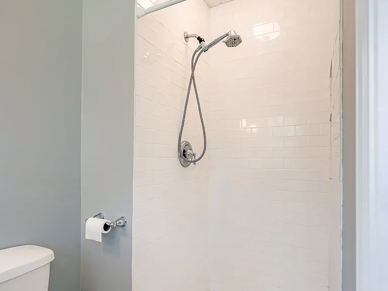 Master bathroom shower featuring shower light/fan combo and built in tile shelving