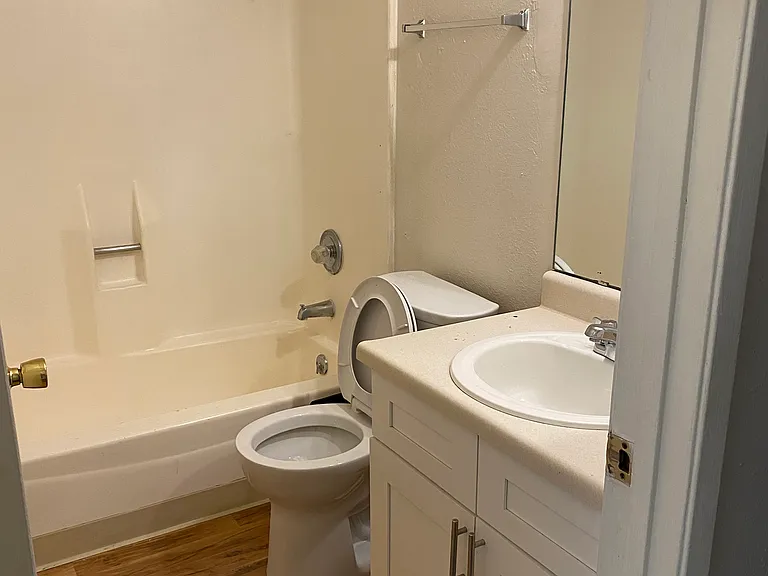 Full bathroom with newer wood, laminate floor.