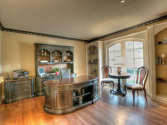 Study or formal living room with hardwood floor and custom built-in shelves.