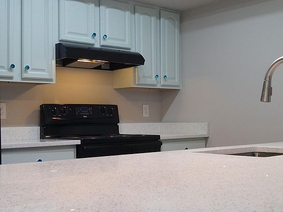 Newly renovated kitchen with quartz countertops and light teal cabinets