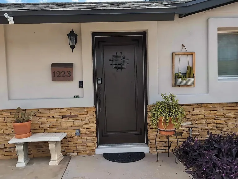 Front door of our Fully Furnished Tempe Rental Home front view. Fully renovated , gravel front yard with low maintenance desert landscape including palm trees, beautiful cactus. Monthly furnished Tempe rental property