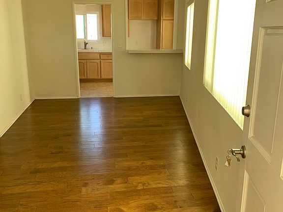 from front door into living room toward kitchen & dining area ( lighting at dusk caused yellow tinge)