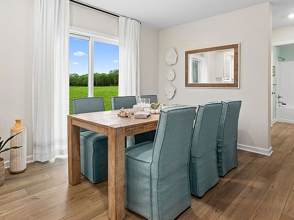 Dining room with large double window n a DRB Homes Whitehall model home at The Village of College P