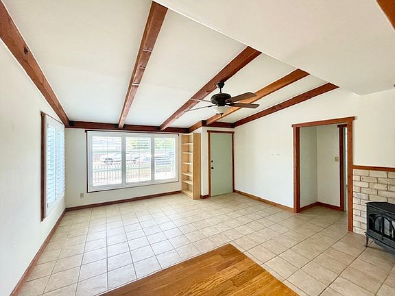 Beautiful living space featuring high ceilings, a ceiling fan and gorgeous wooden beams