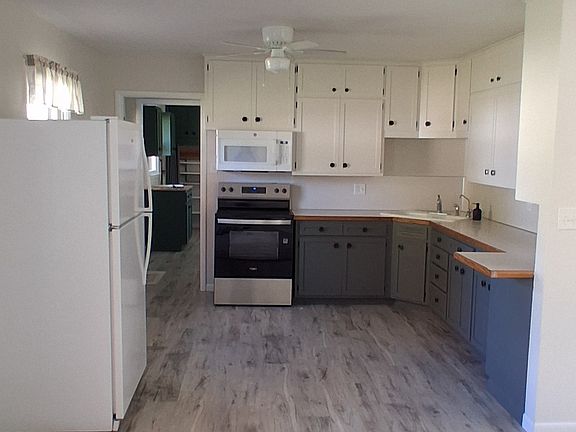 Kitchen with dining area in foreground. Living room to the right.