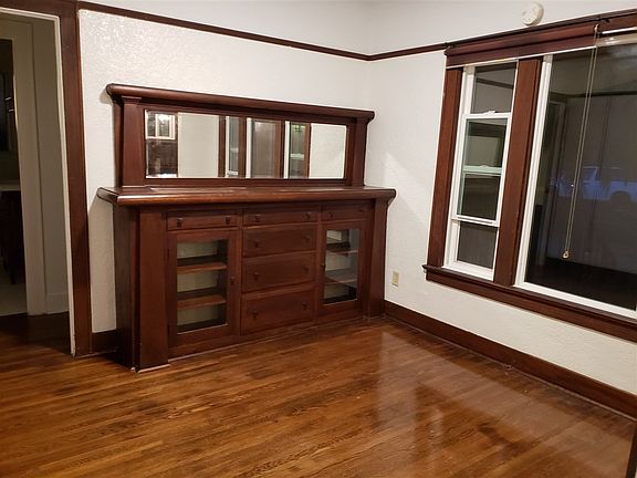 Dining area with updated windows, original built in hutch and hardwood floor.