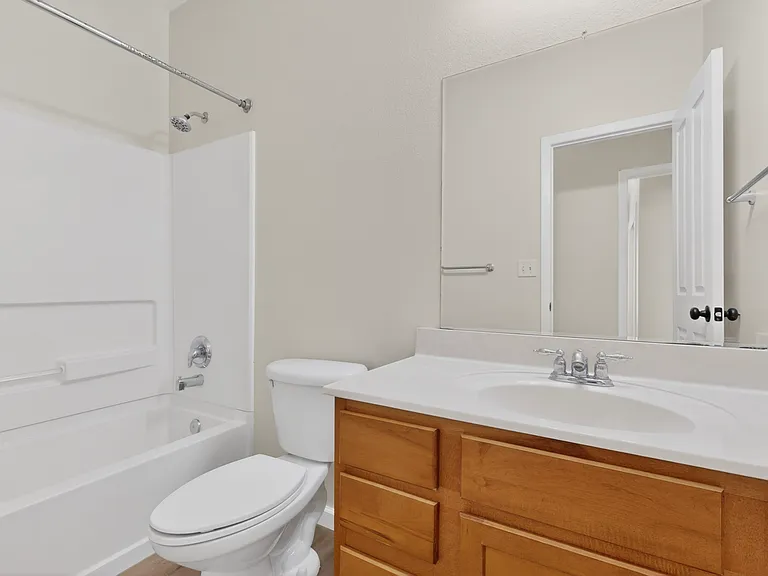 A full hall bath features space a large vanity with plenty of countertop and storage, a commode and a full Tub/shower combo to serve the two bedrooms and guests alike.