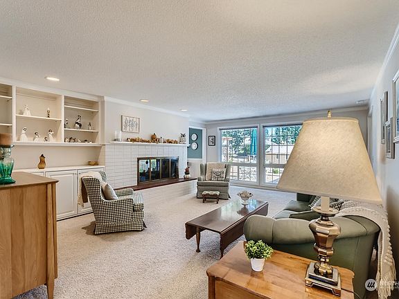 Spacious living room looks out on the peaceful back yard and has floor to ceiling windows to bring in loads of natural light.>