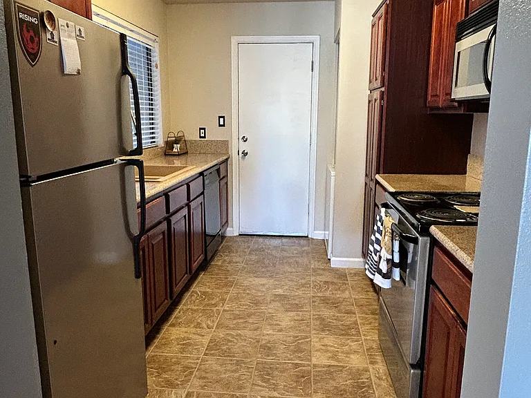 Galley style kitchen - contains garage entrance and stackable washer/dryer