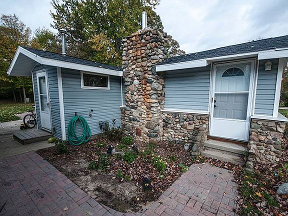 Beautiful field stone work on the exterior with a newer brick pathway leading to the back door.