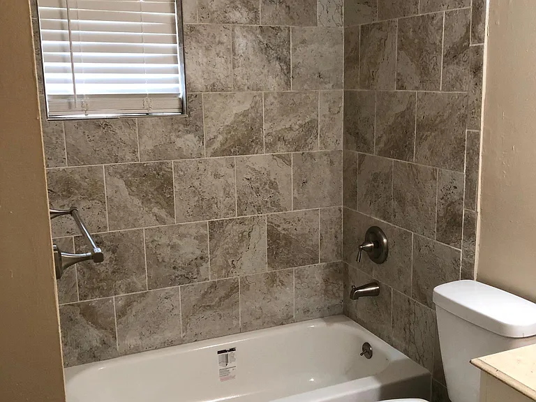 Updated bathroom with soaker tub, porcelain tile shower walls and brushed nickel fixtures.