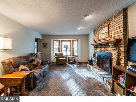 Main floor family room with gas fireplace and bay window overlooking the front yard.