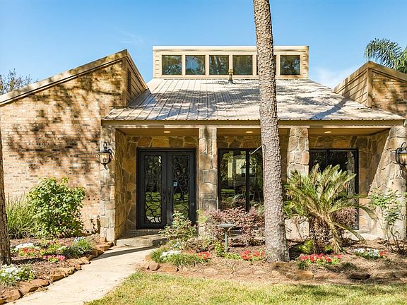 Front porch with stone column accents and decorative metal/glass doors