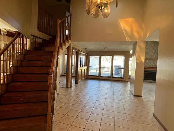 A stair leading to the 3 bedrooms upstairs, kitchen on the far left-hand side with breakfast room, game room and living room on the right.