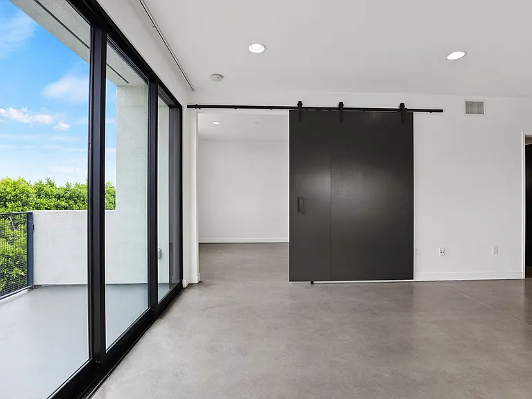 Living Room with Spacious Patio, Concrete Flooring, and Recessed Lighting