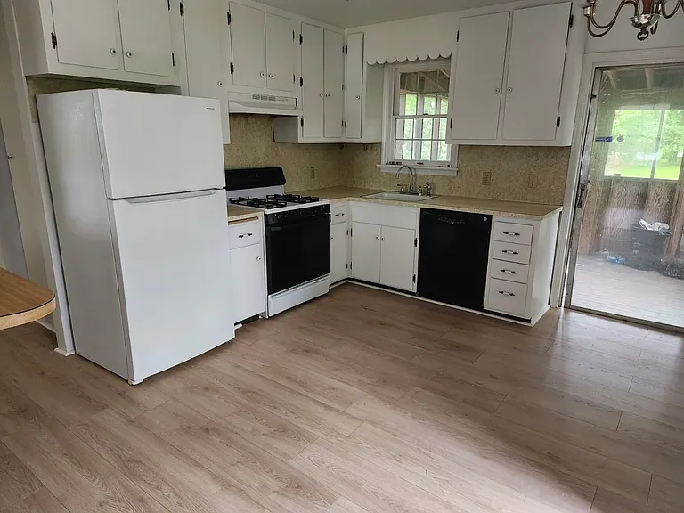Kitchen with fridge, dishwasher, stove, oven.