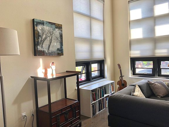Looking southeast, honeycomb blinds filter light from 20' windows.
