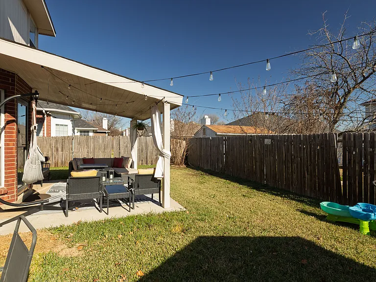 Cozy covered patio with a hammock and stylish seating.