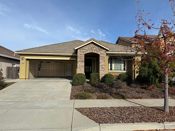 Front of the house with open garage door.