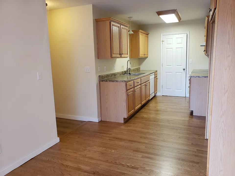 Stove, dishwasher, and garbage disposal, with cabinets along both walls.