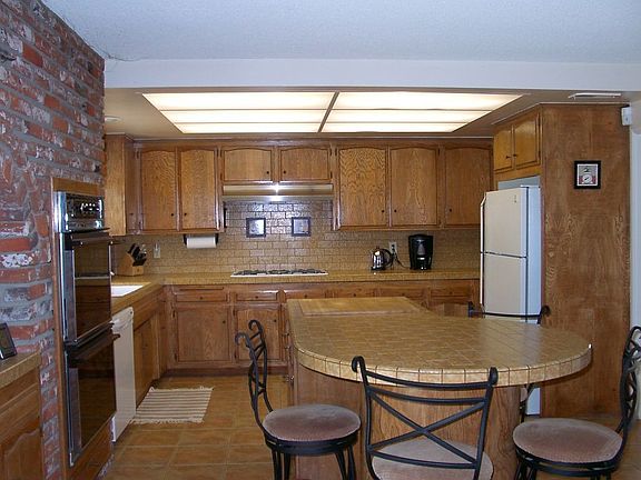 Sunny kitchen with island, double ovens, walk-in pantry