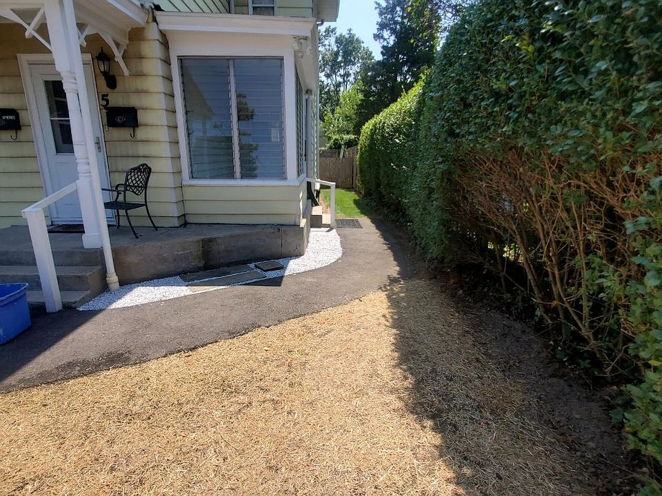 view from front yard to glassed in porch main entrance , (*hayed area has been seeded and will become grass.)