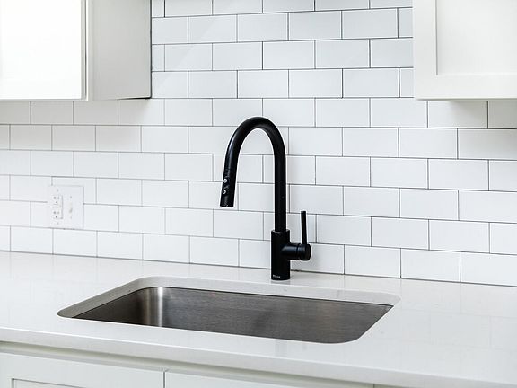 Kitchen with white quartz countertops and tile backsplash