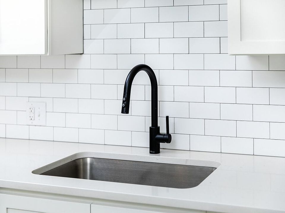 Kitchen with white quartz countertops and tile backsplash