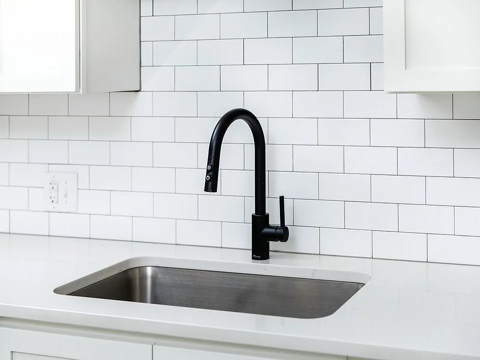 Kitchen with white quartz countertops and tile backsplash