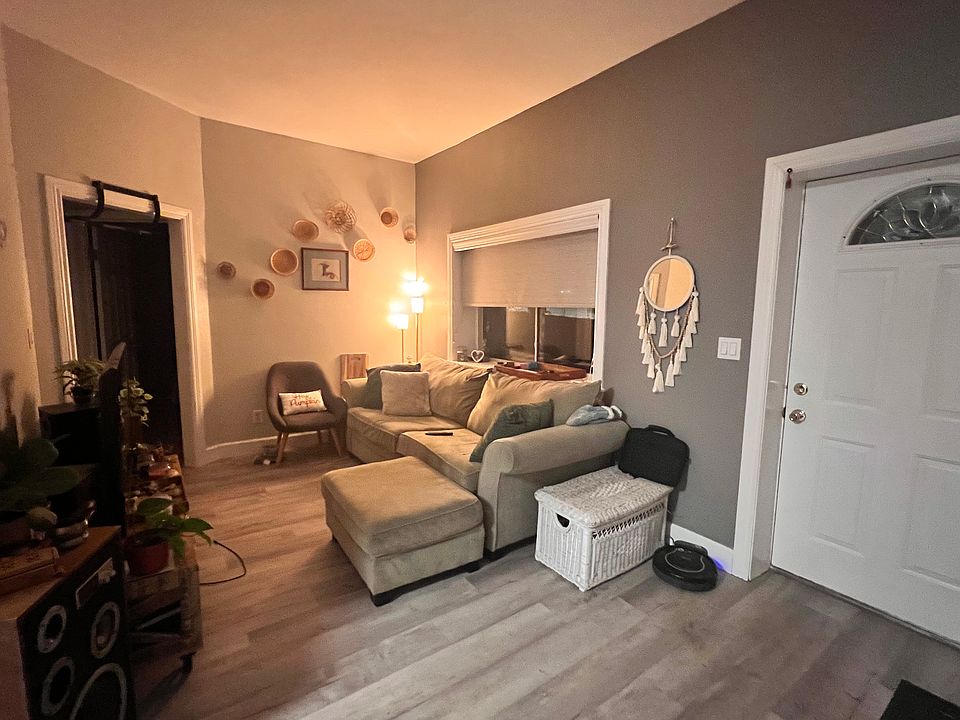 Living room

Large window behind couch, entry door, light and dark grey walls and grey, vinyl, wood-grain flooring.