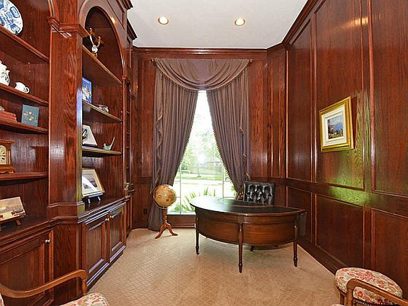 THE STUDY IS ENHANCED BY RICH PANELED WALLS AND CUSTOM CRAFTED BOOK SHELVES!