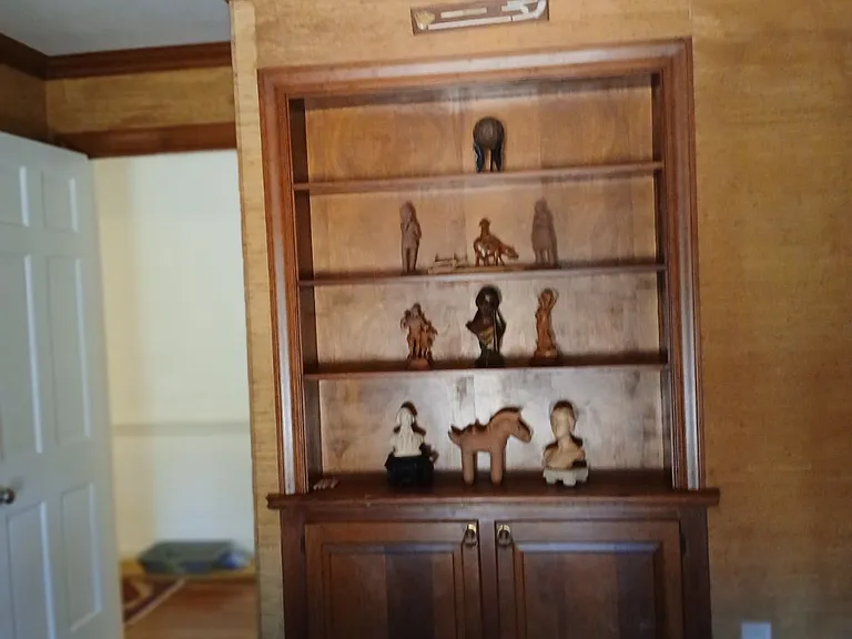 The library and family room includes built in shelves and grass paper wallpaper.