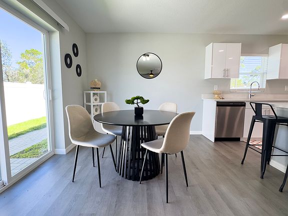 Cozy dining area filled with natural light and a direct view of the kitchen, living room, and backyard.