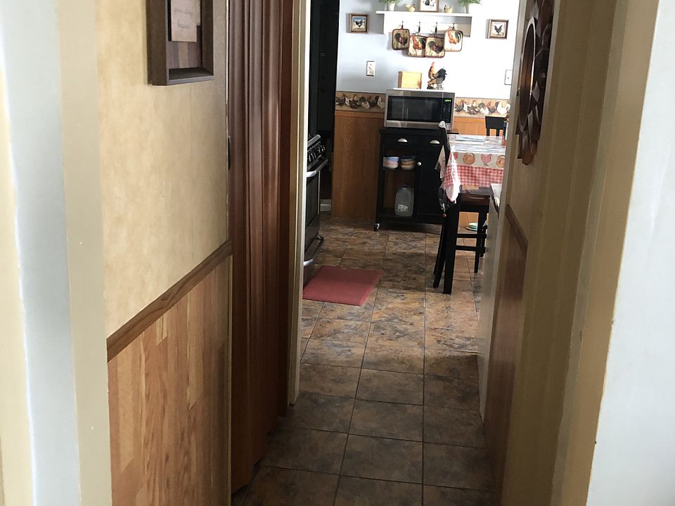Hallway with bath off right side and pantry with washer hookup off left side
